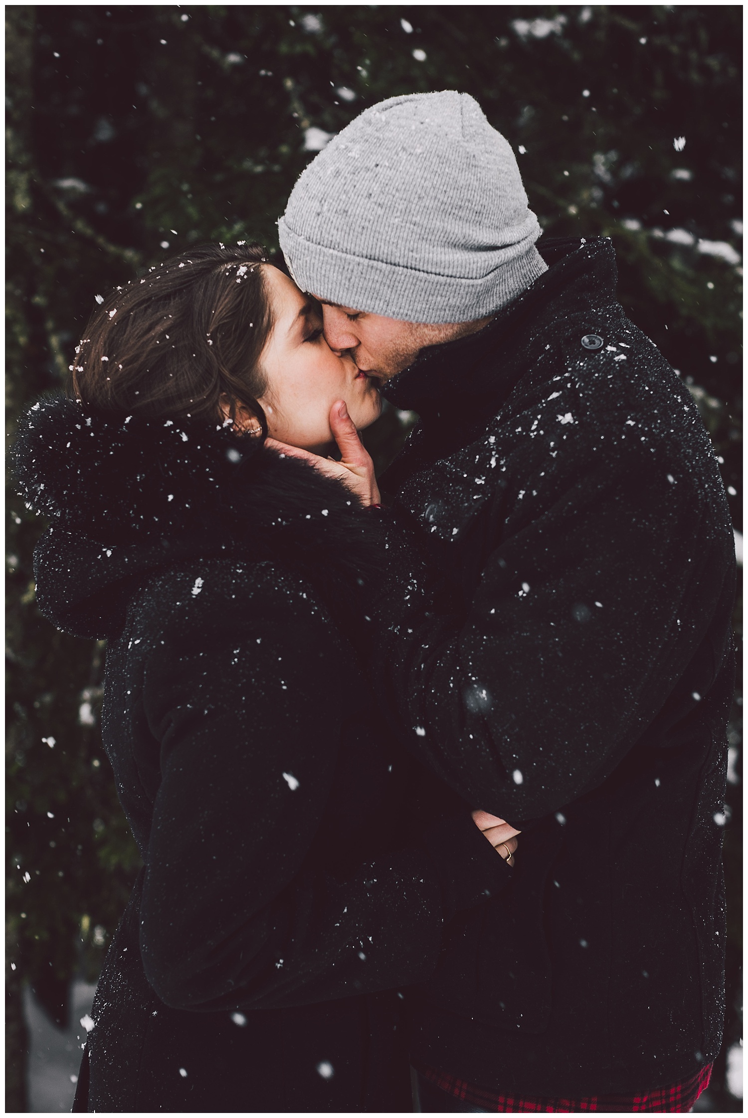 Kissing in the snow for their engagement photos