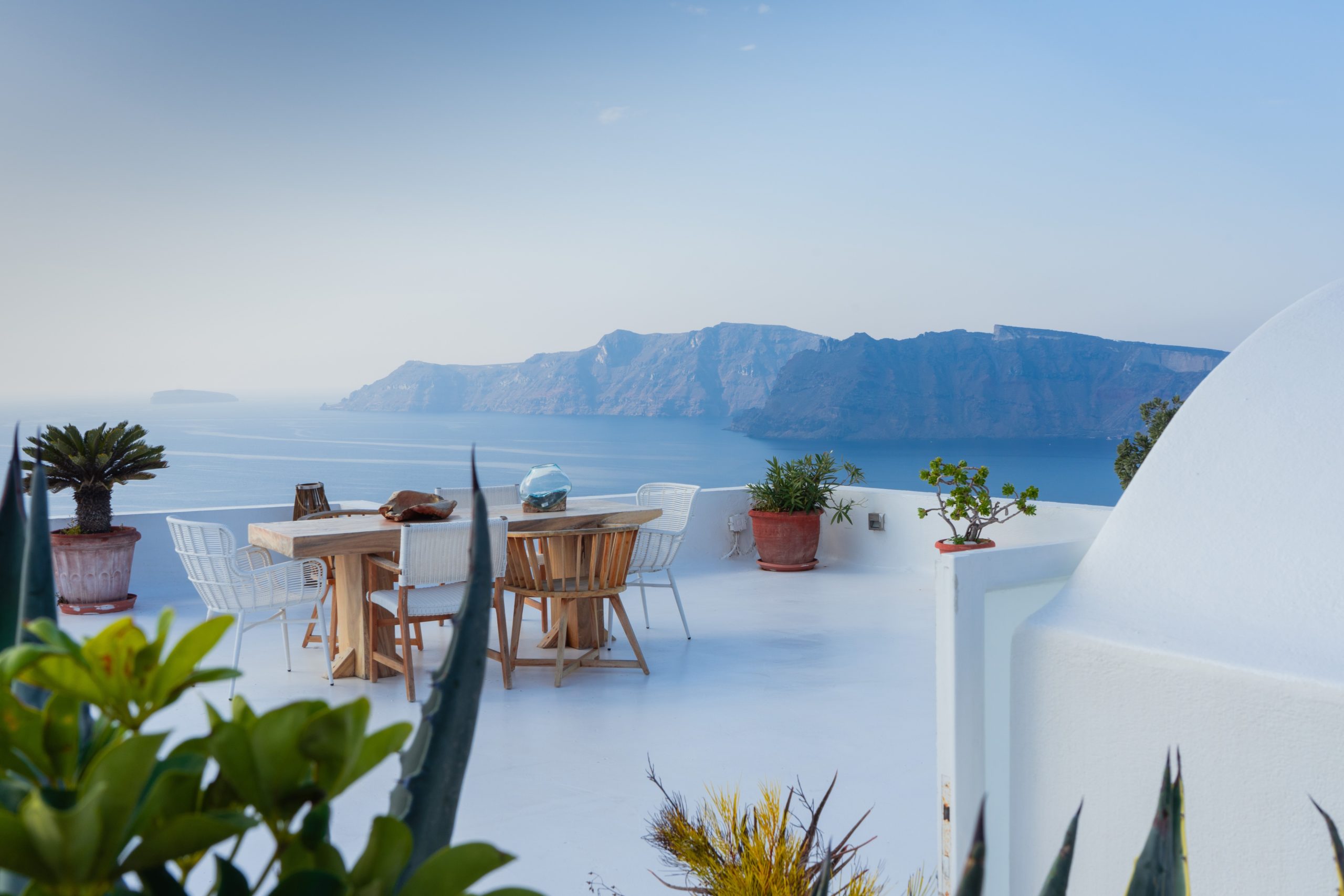 Imagine sitting here on this modern white rooftop deck in Santorini on your wedding night looking over the Aegean Sea.